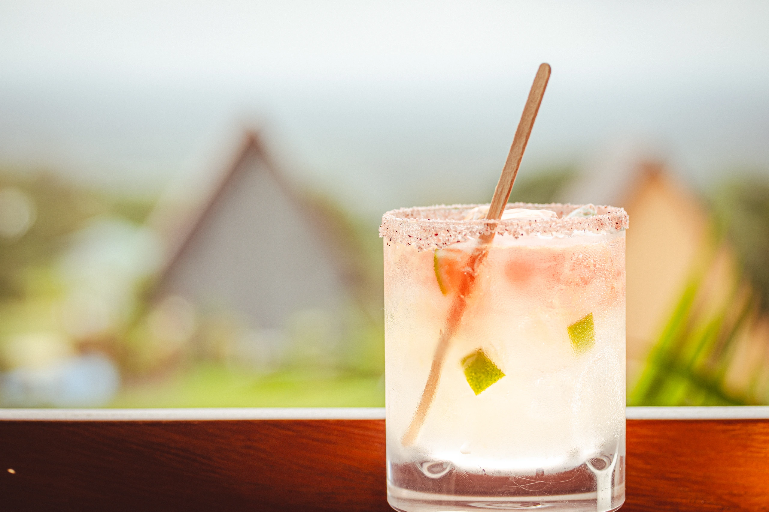 A colourful drink with Junglo bungalows in the background